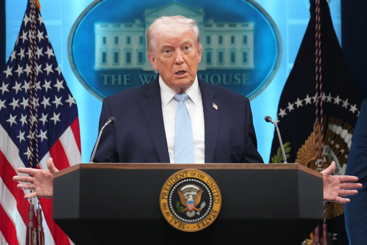 Donald Trump speaking at a podium.